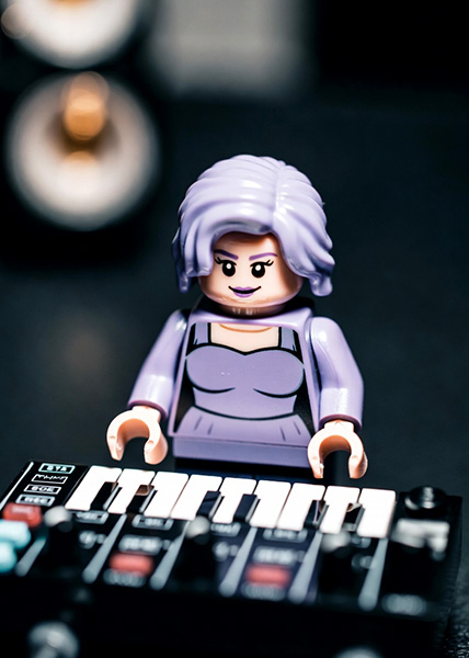 A female musician at a mixing desk in a studio.