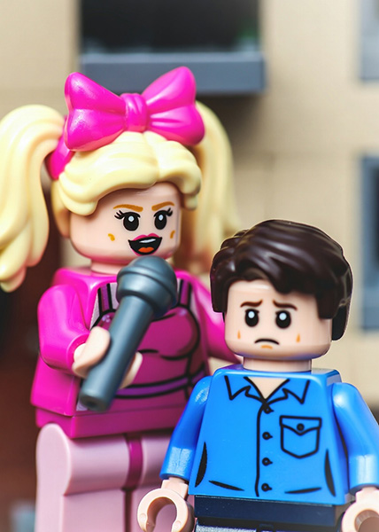 A female superstar pop singer singing to an upset young male fan.